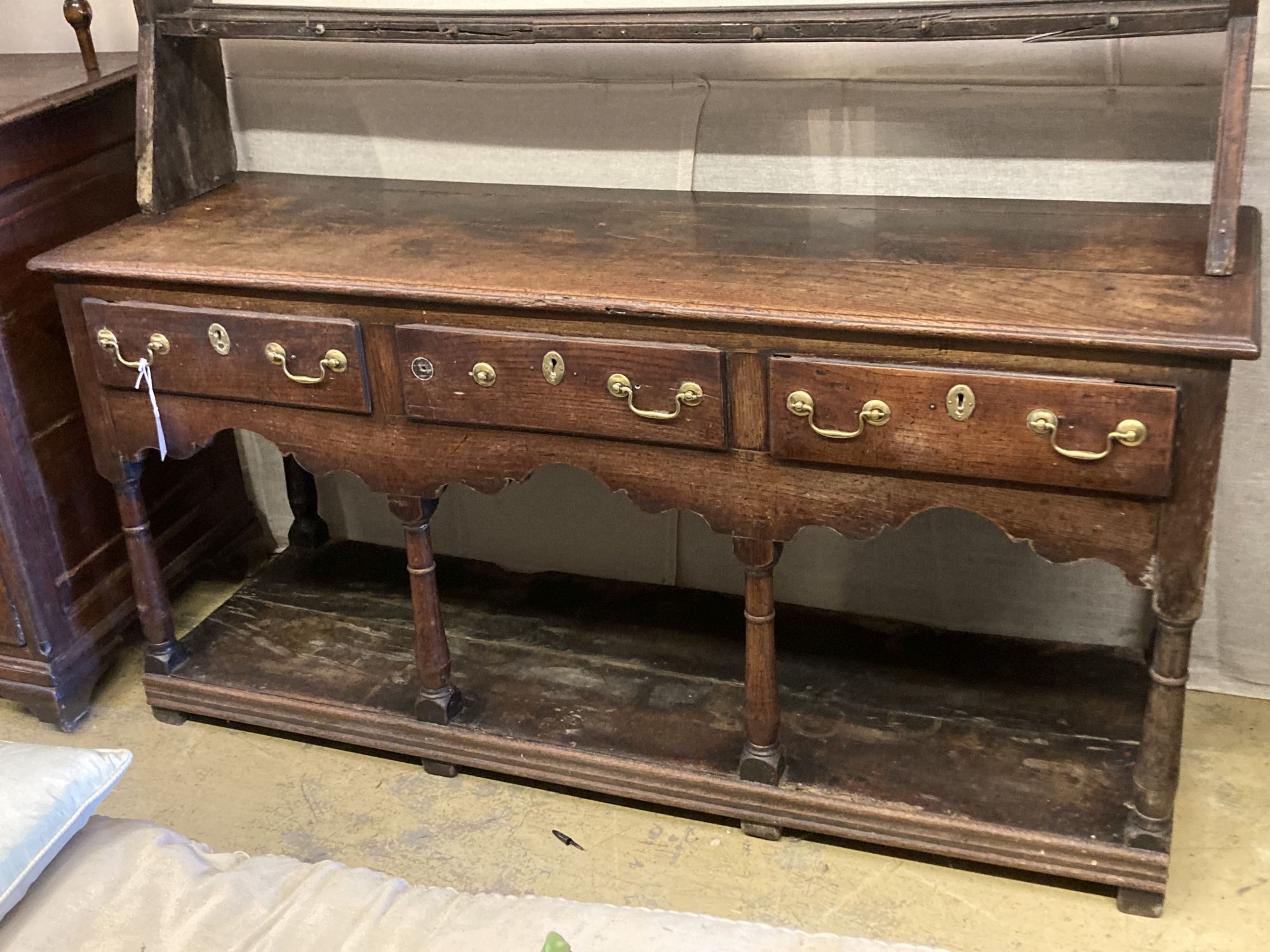 An 18th century oak potboard low dresser with associated rack, length 152cm, depth 48cm, height 193cm